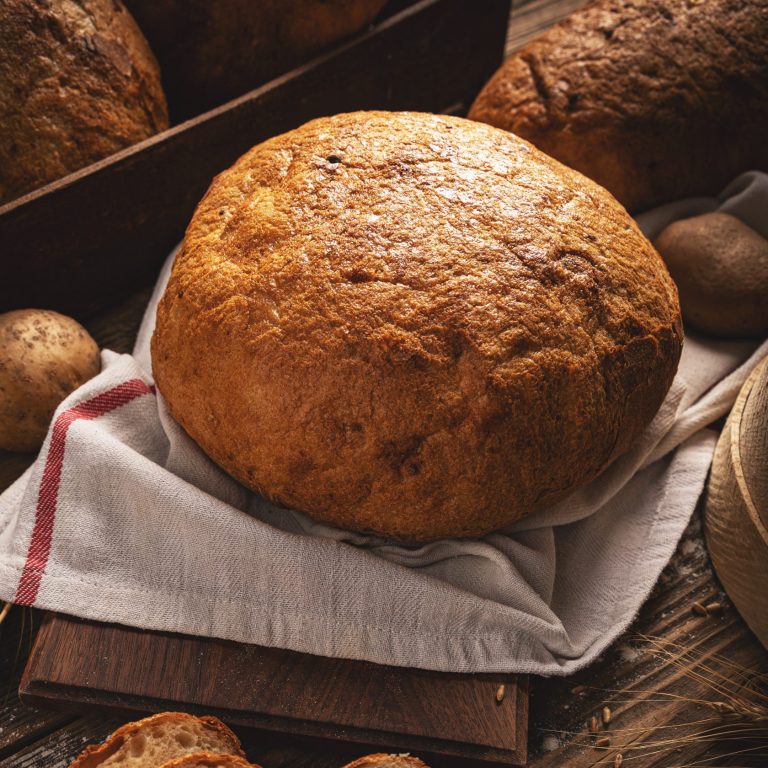 Fresh bread and wheat on the wooden background, bakery concept